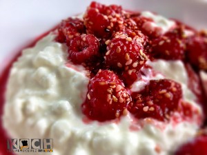 Heiße Himbeeren auf Hüttenkäsecreme